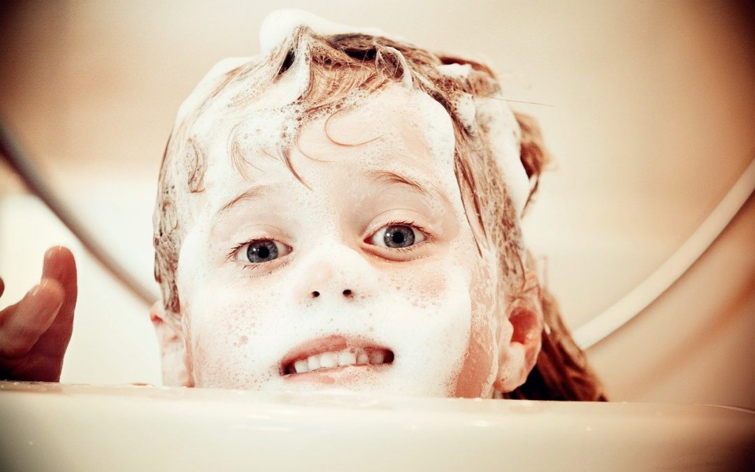 Kind mit Shampooschaum auf dem Kopf
